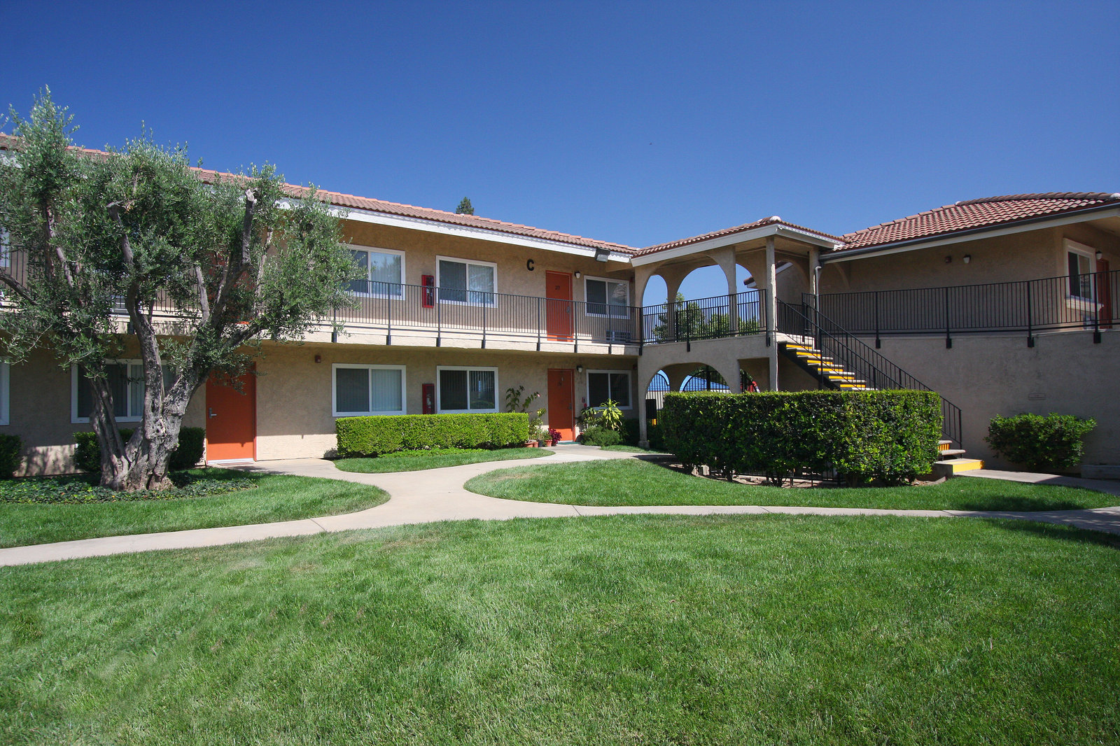 Landscaped lawn and walkways in the courtyard between two-story apartment wings